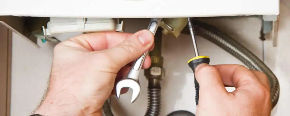 Boiler repair technician tightening pipe fittings and connections in Cleveland, OH