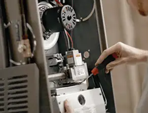 Furnace repair technician inspecting internal components and wiring in Cleveland, OH