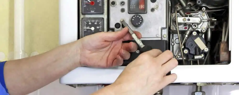 Heating repair technician adjusting boiler controls and components in Cleveland, OH