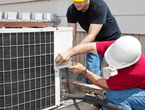 HVAC technicians repairing an outdoor AC unit on a rooftop in Cleveland, OH