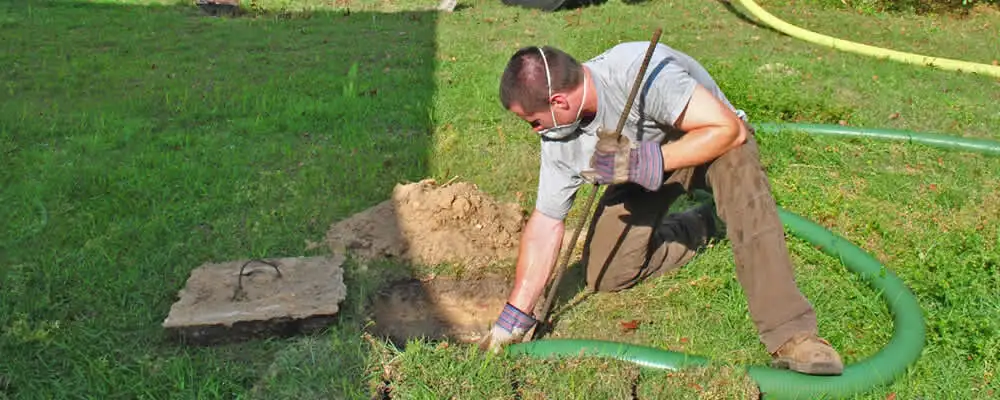 Septic pumping technician servicing a residential septic tank in Cleveland, OH