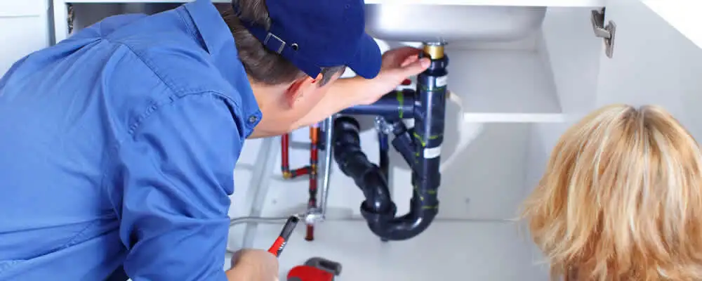 Plumber repairing under-sink drain pipes and fittings in Cleveland, OH